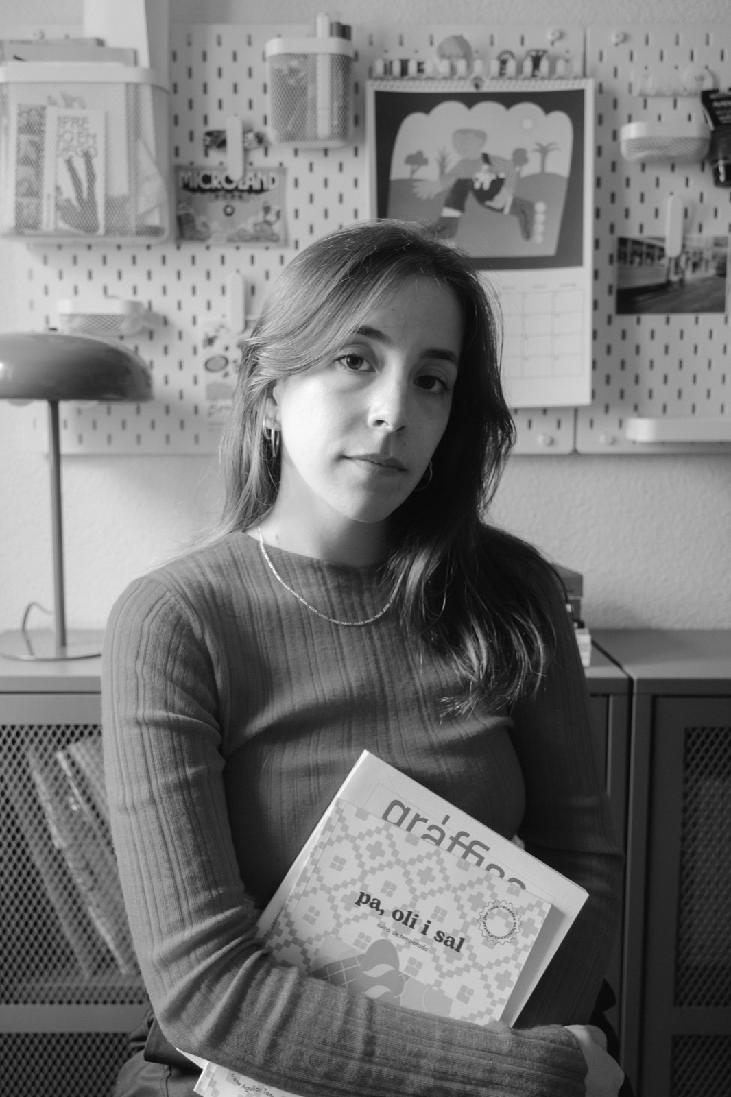 Irene Agarit, designer, in her studio holding a publication